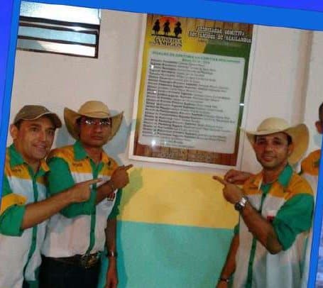 Kell e amigos de chapéu de vaqueiro em frente a uma placa