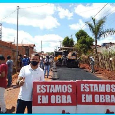 Kell diante de placas de 'Estamos em obra' em uma rua sendo asfaltada