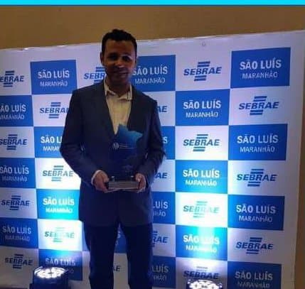 Kell de terno segurando um troféu em evento do Sebrae em São Luís